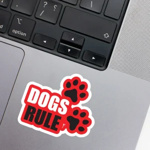 Vinyl Laptop Sticker irregular english text Dogs rule shape with white 3mm outline round corner and white text red background on macbook beside keyboard