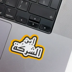 Vinyl Laptop Sticker irregular arabic text Ebn el sherka shape with yellow 3mm outline round corner and black white text on macbook beside keyboard