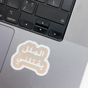 Vinyl Laptop Sticker irregular arabic text Al mallal yaqtolony shape with white 3mm outline round corner and light grey text on macbook beside keyboard