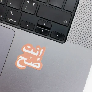Vinyl Laptop Sticker irregular arabic text enta sah shape with simon 3mm outline round corner and white text on macbook beside keyboard