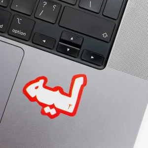 Vinyl Laptop Sticker irregular arabic text leeh shape with orange red 3mm outline round corner and white text on macbook beside keyboard
