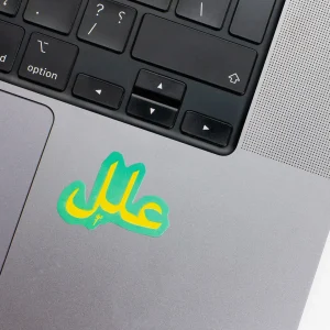 Vinyl Laptop Sticker irregular arabic text allel shape with teal 3mm outline round corner and yellow text on macbook beside keyboard
