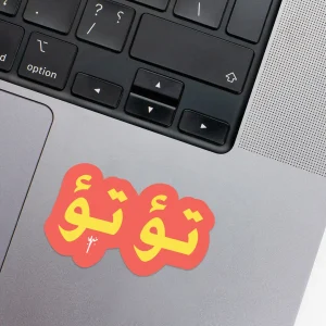 Vinyl Laptop Sticker irregular arabic text to' to' shape with orange simon 3mm outline round corner and yellow text on macbook beside keyboard