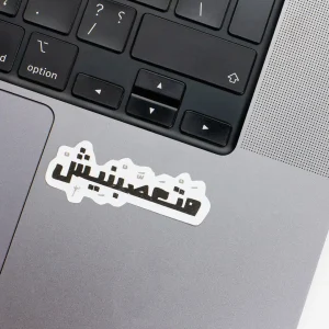 Vinyl Laptop Sticker irregular arabic text matasabneesh shape with white 3mm outline round corner and black text on macbook beside keyboard