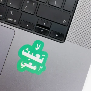 Vinyl Laptop Sticker irregular arabic text la taabath shape with teal 3mm outline round corner and white text on macbook beside keyboard