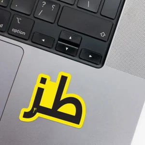 Vinyl Laptop Sticker irregular arabic text toz shape with yellow 3mm outline round corner and black text on macbook beside keyboard