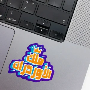 Vinyl Laptop Sticker irregular arabic text malek el orderat shape with blue 3mm outline round corner and orange white text on macbook beside keyboard