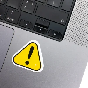 Vinyl Laptop Sticker irregular Warning Sign shape with white 3mm outline round corner and black exclamation mark on macbook beside keyboard