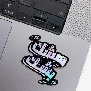 Holographic Laptop Sticker irregular arabic text heshek beshek shape with round corner with black text on macbook beside keyboard with inner fill shiny metallic rainbow effect