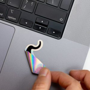 Holographic Laptop Sticker irregular shape of black cat with round corner on macbook beside keyboard peeled off by hand with inner fill shiny metallic rainbow effect