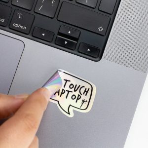 Holographic Laptop Sticker rectangle shape with round corner with black text dont touch my laptop on macbook beside keyboard peeled off with inner fill shiny metallic rainbow effect