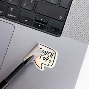 Holographic Laptop Sticker rectangle shape with round corner with black text dont touch my laptop on macbook beside keyboard peeled off using a black marker with inner fill shiny metallic rainbow effect